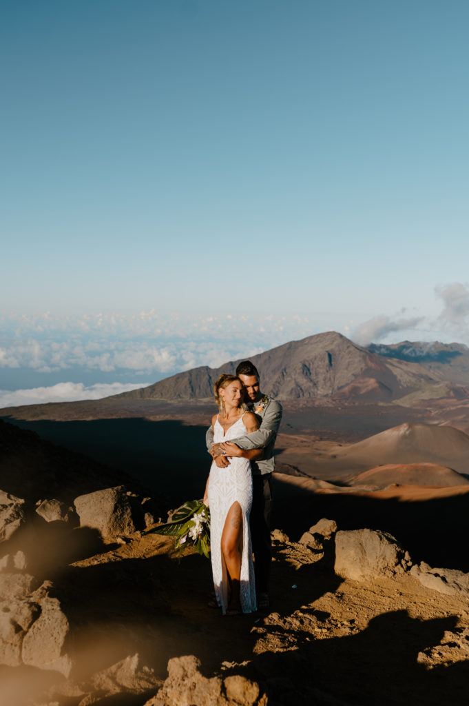 A couple embraces on an overlook in Haleakala National Park during their elopement.