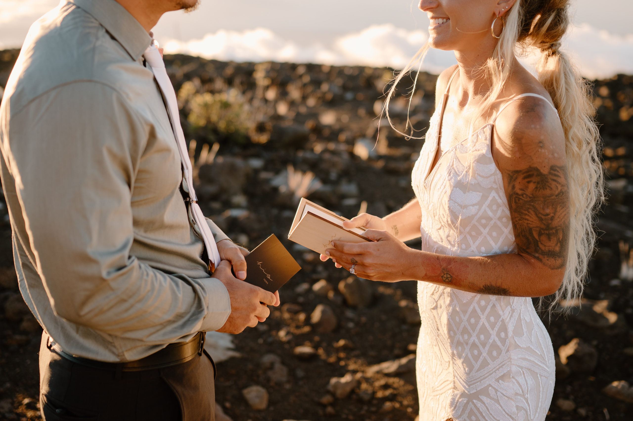 A bride and groom say their vows while standing on Haleakala Summit in Maui