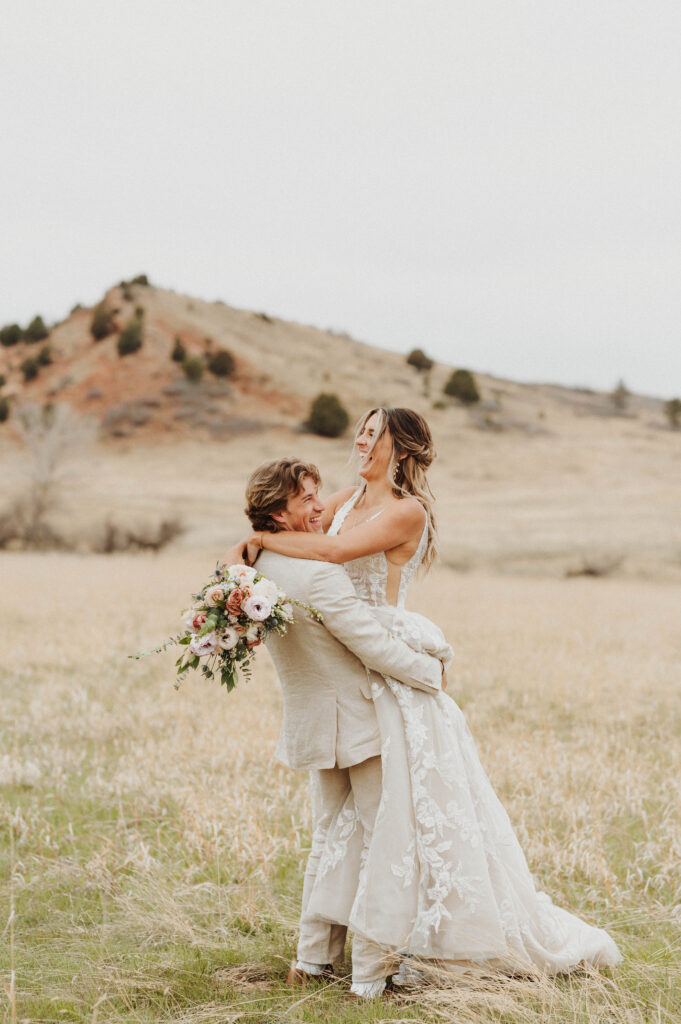 A groom hugs his bride after their elopement in the Rocky Mountains