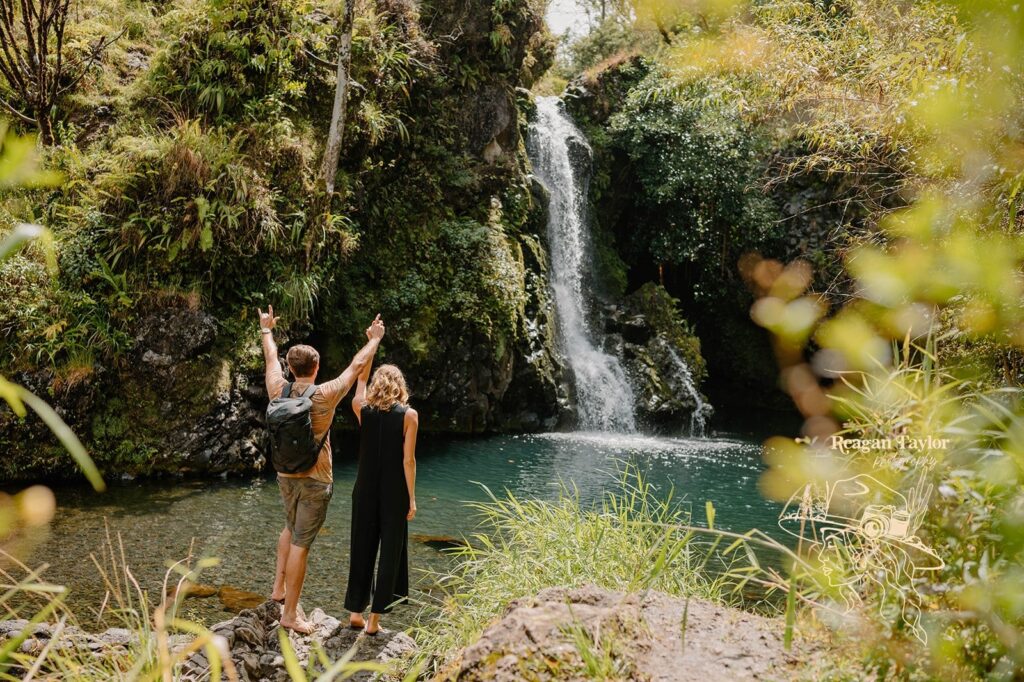 A couple celebrates their elopement near a tropical waterfall 