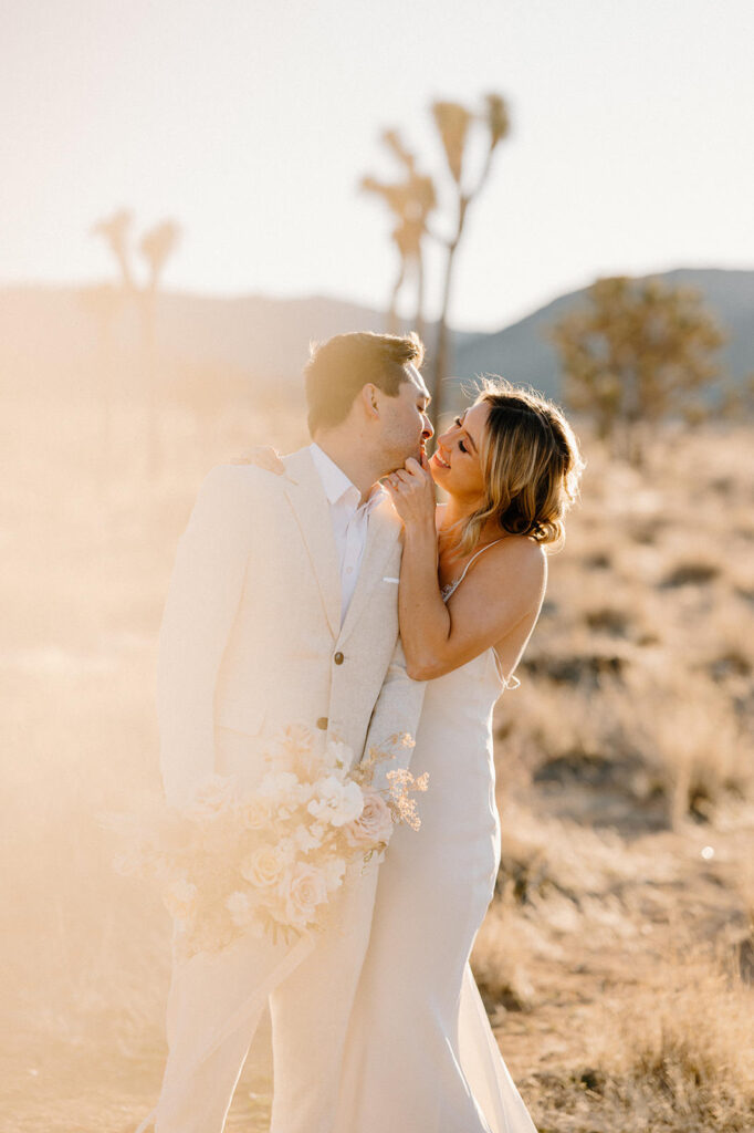 A bride and groom embrace for a kiss for their intimate desert wedding near Palm Springs