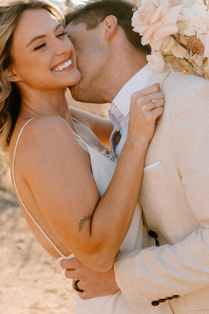 A man kisses his wife in celebration of their California National Park elopement in the desert