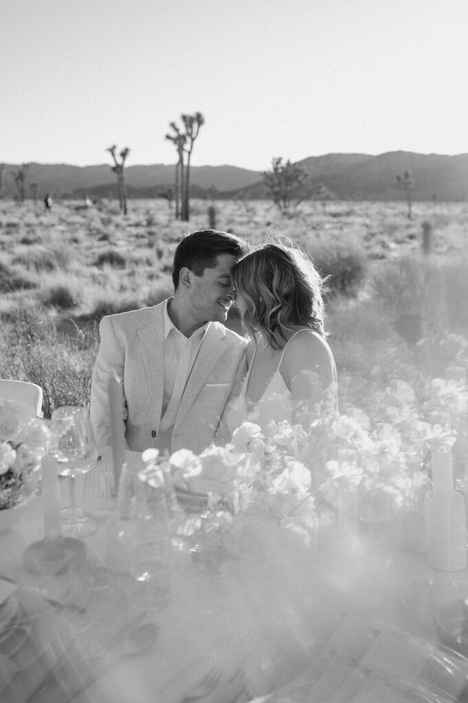 A man and woman are seating at a tablescape in Joshua Tree celebrating their marriage