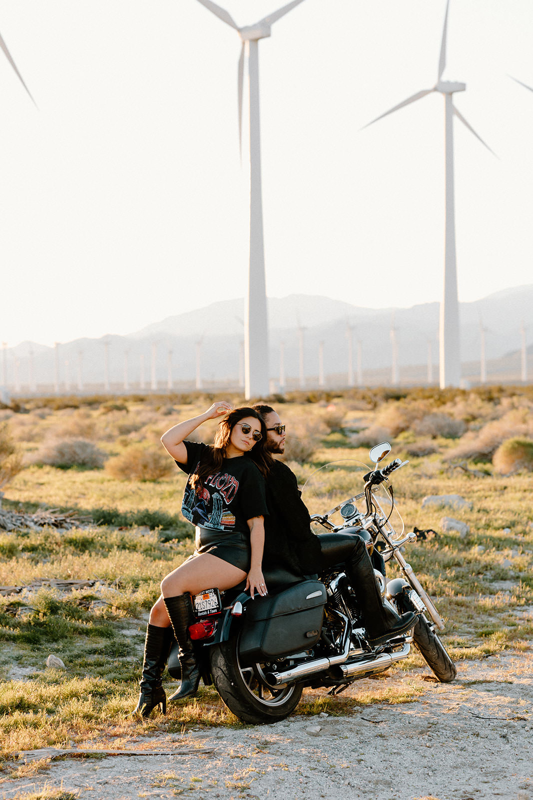 A couple poses on a motorcycle for during a Palm Springs couple getaway in California for their anniversary