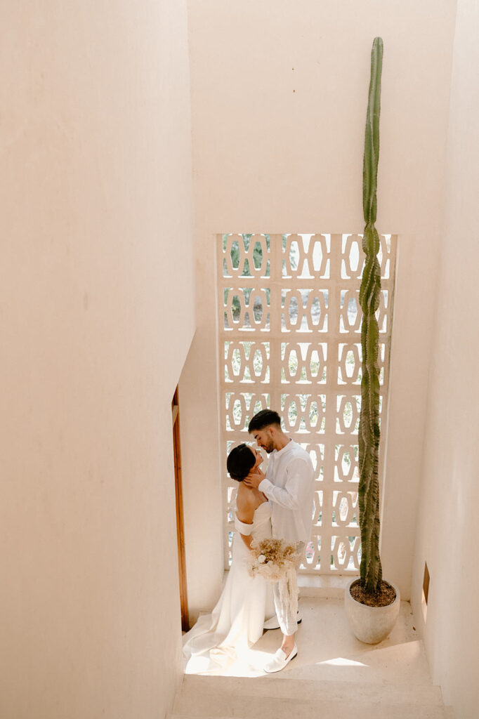 A couple poses in a staircase for their Tulum elopement