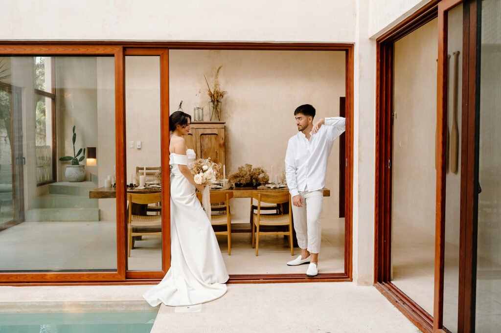 A couple poses in a doorframe at a Mexico Airbnb in Tulum for their tropical elopement