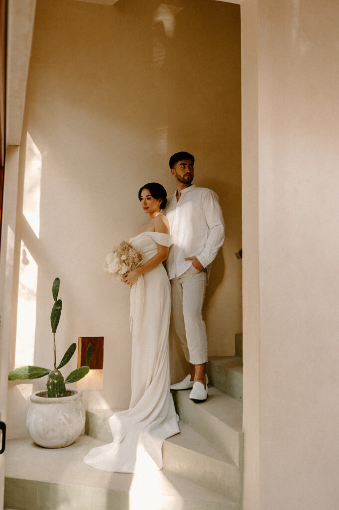 A couple poses at an Airbnb in Tulum during their destination wedding
