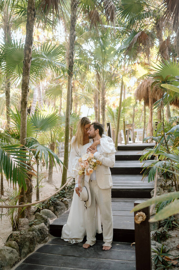 A couple stands on a wooden boardwalk at Casa Violeta in Tulum