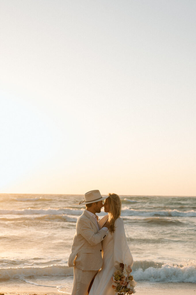 A couple kisses on a beach after their adventure elopement vows in Tulum