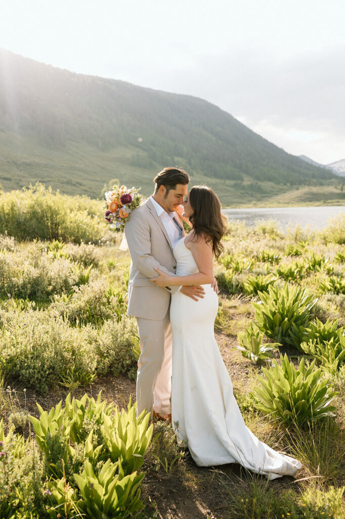 A couple embraces beneath the Rockies for their Crested Butte elopement at Harmels On The