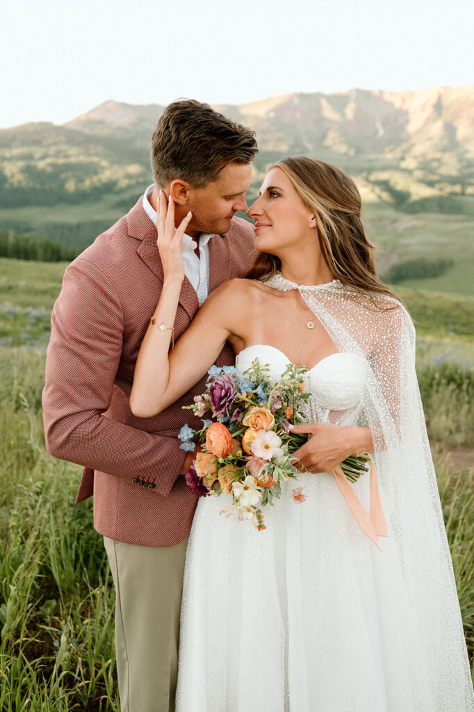 A bride holds Summer wedding florals in Crested Butte.