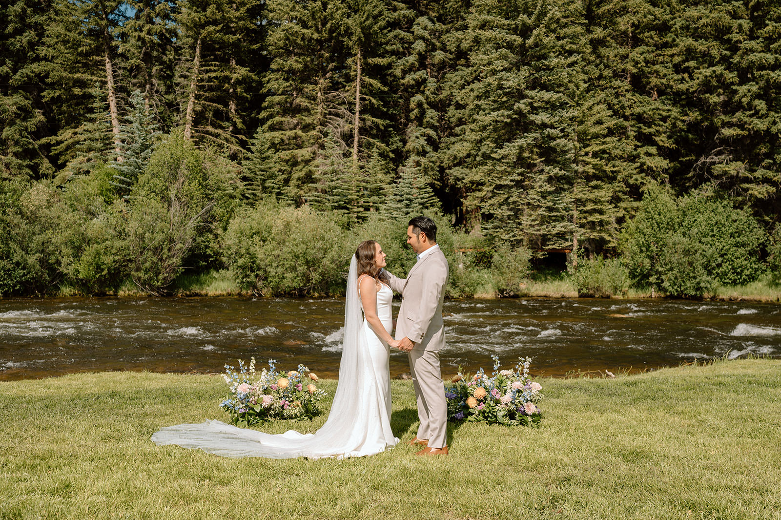 A couple says their vows on the bank of the Taylor River at Harmels On The Taylor