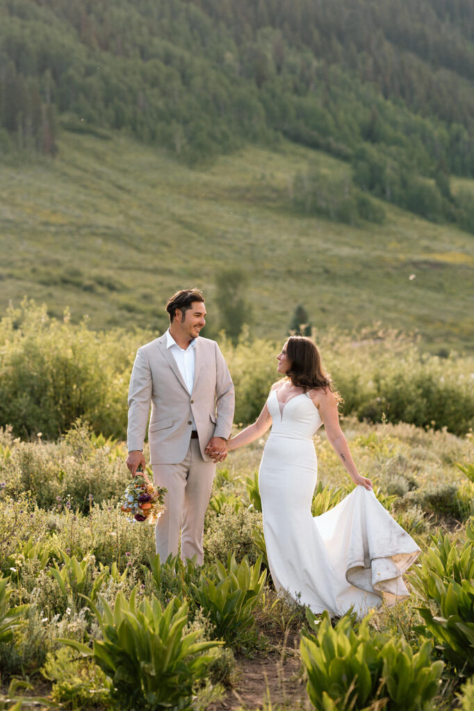 A couple walks near wildflowers in Crested Butte.