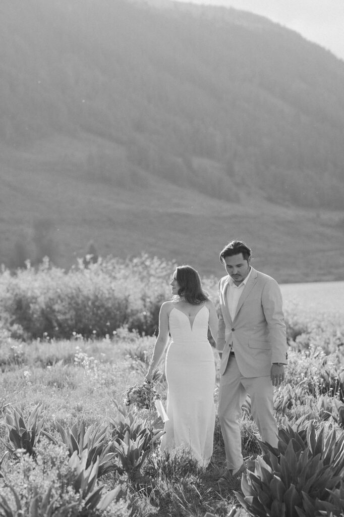 A couple holds hands in wedding attire after their Colorado adventure elopement.