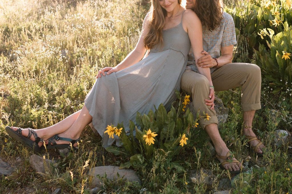 A couple poses near wildflowers in Crested Butte