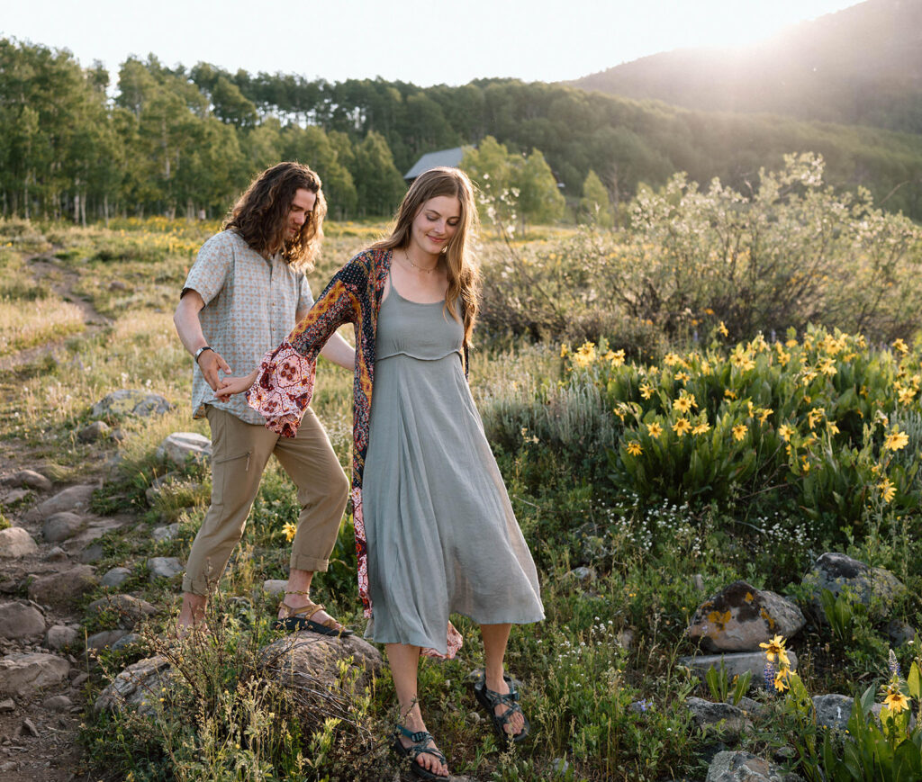 A couple adventures along a hiking trail, observing Colorado wildflowers in Summer