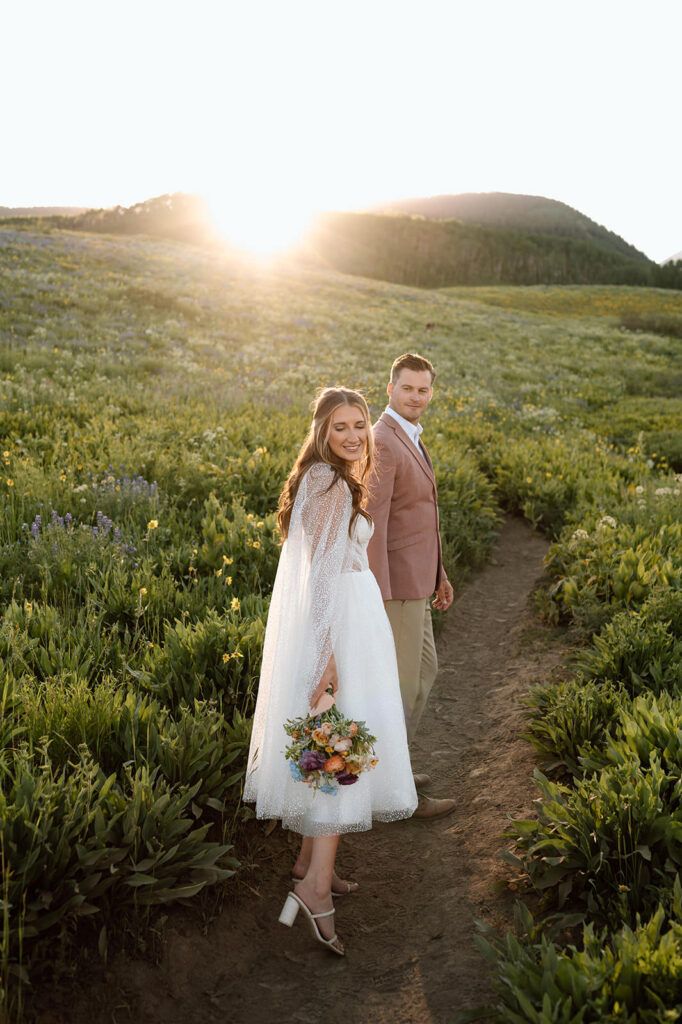 A bride follows her groom on a hiking trails in Coloradod.