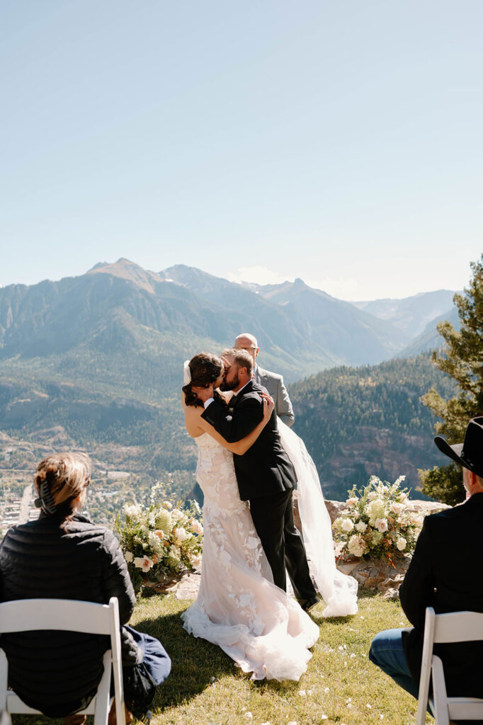 A bride and groom kiss after saying I Do on at a ranch in Ouray.