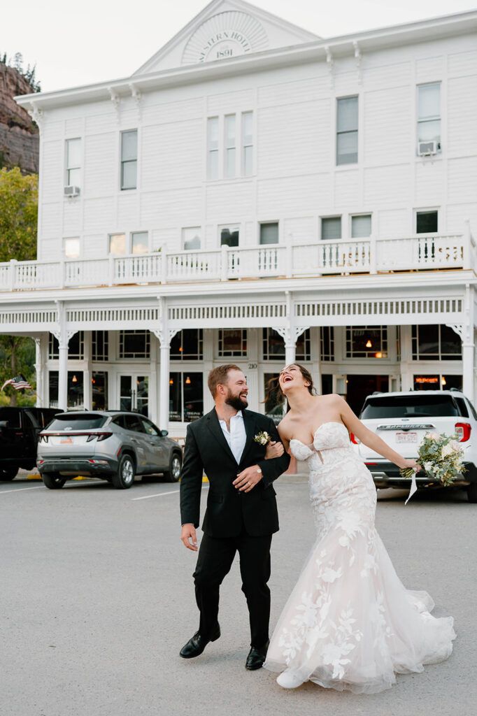 A couple laughs while adventuring along Ouray's Main Street after their mountain wedding. 