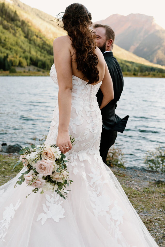 A couple walks along a lake path in Ouray, Colorado after their intimate wedding. 