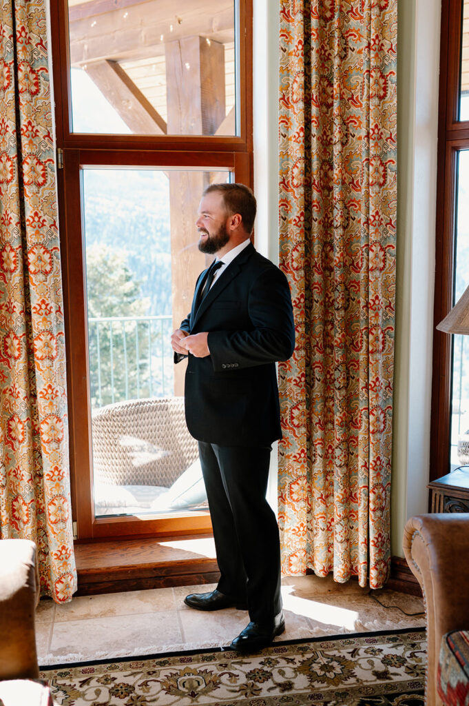 A man buttons up his suit before his Ouray elopement.
