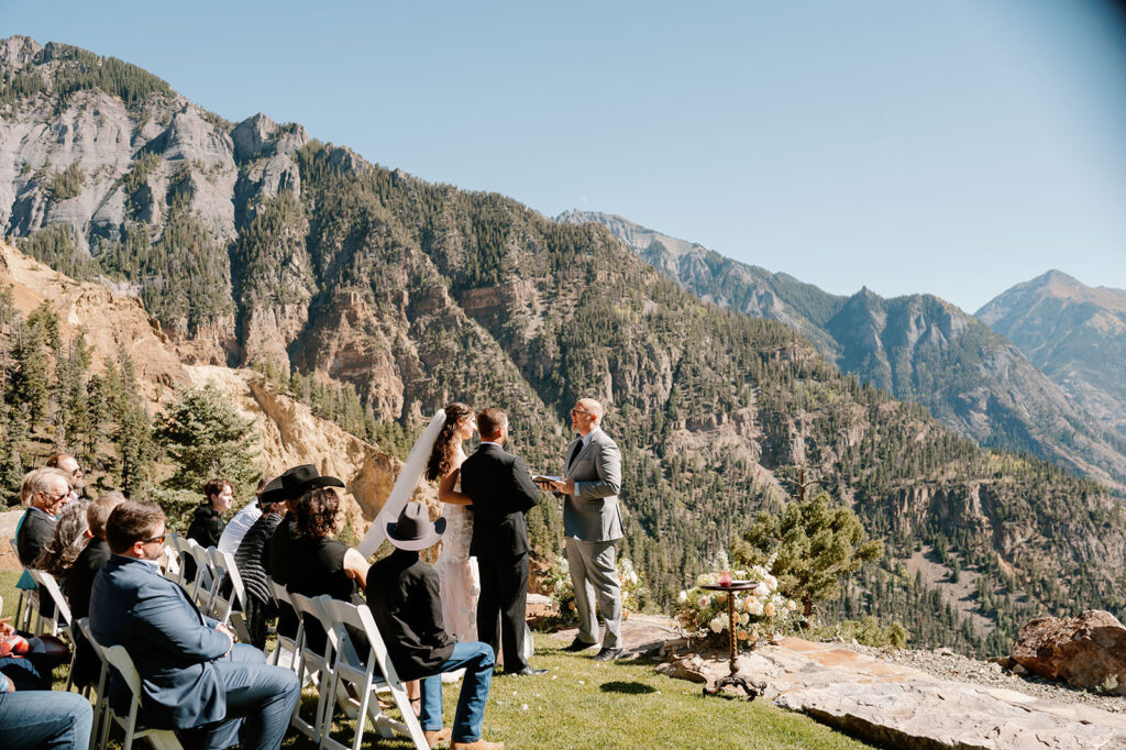 An officiant speaks to a couple getting married in Ouray, Colorado, during their mountain elopement. 