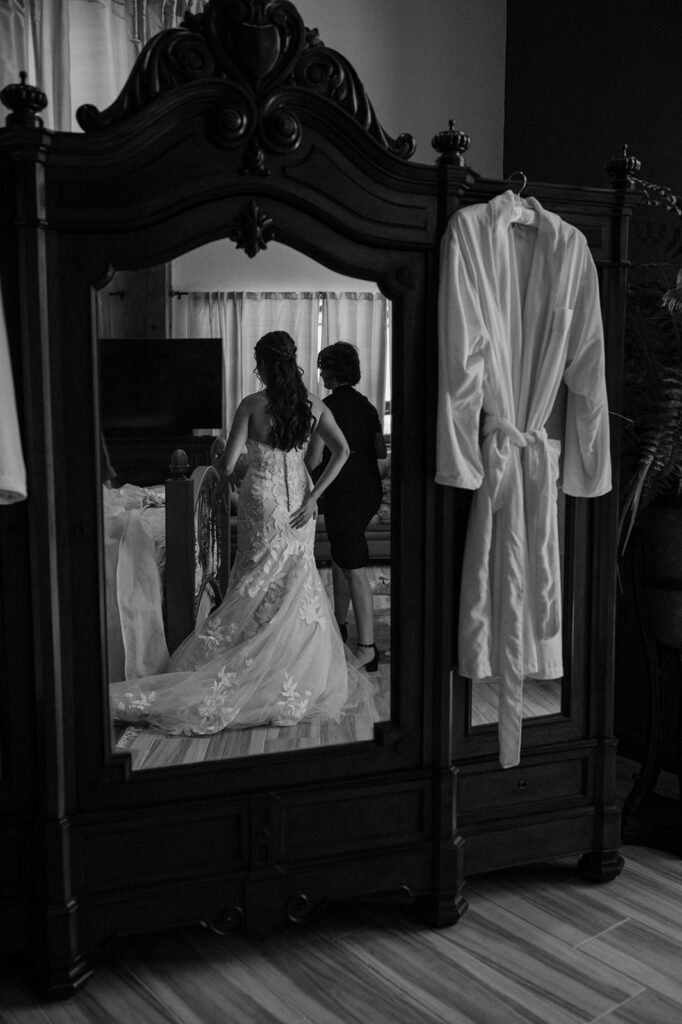 A woman is seen in the reflection of a mirror in her bridal suite just before her Ouray wedding at Golden Mountain Ranch. 
