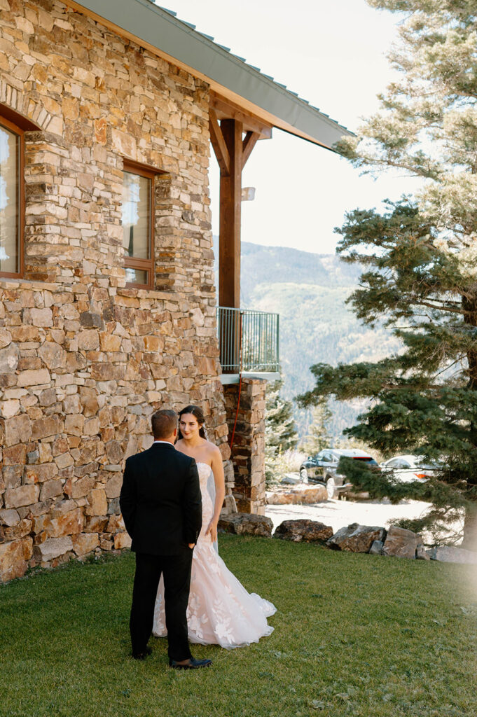 A couple stands near a ranch lodge during their first look in Ouray, Colordo. 