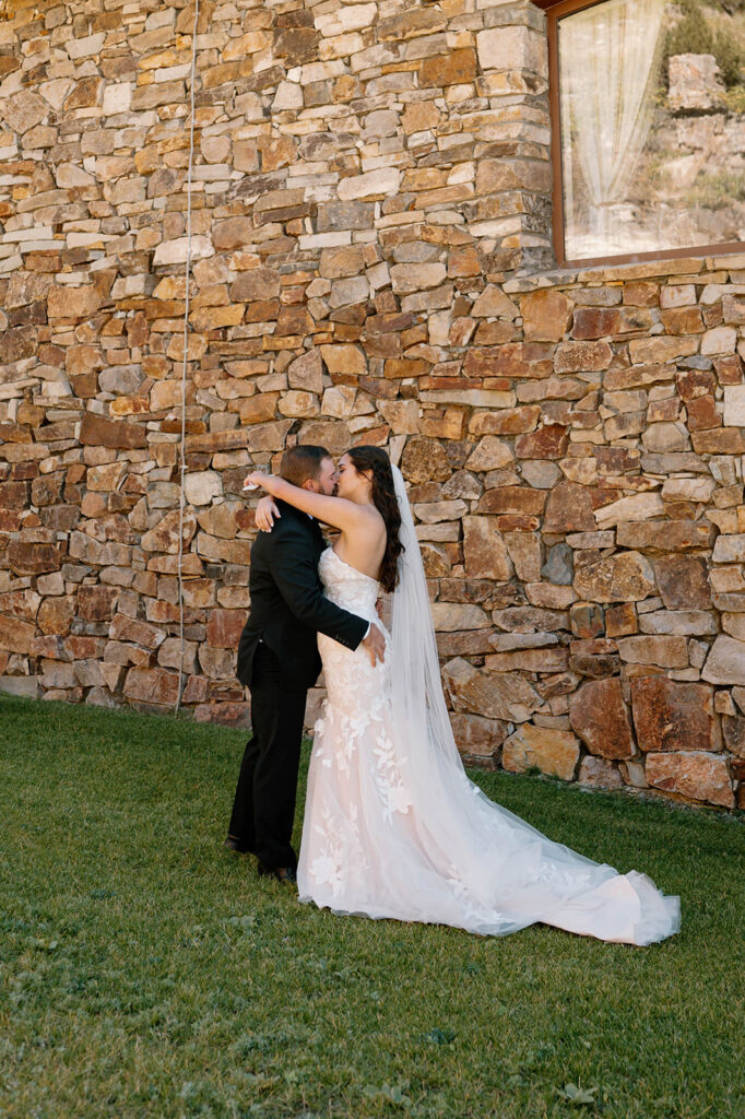 A couple kisses near a ranch lodge during their Ouray, Colorado, intimate wedding. 