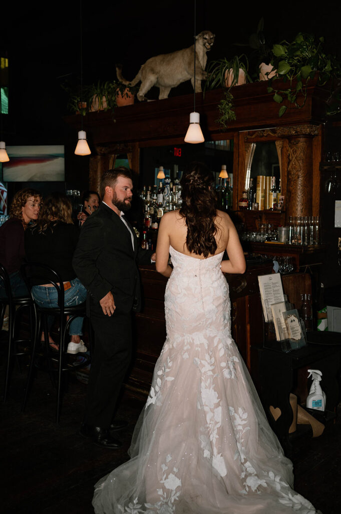 A newlywed couple get a drank at a saloon in Colorado.  