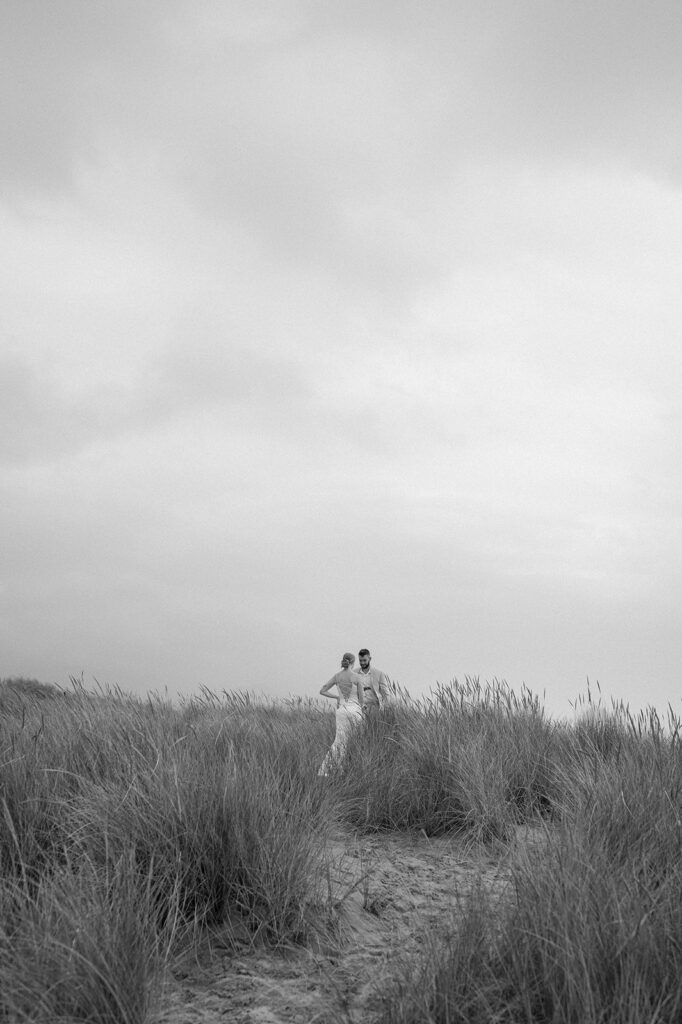 A couple stands in a grassy meadow in Oregon.