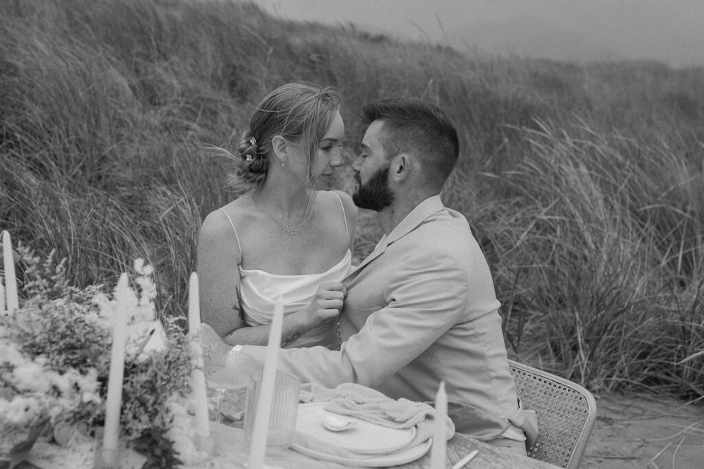 A couple embraces during an elopement picnic at the beach. 
