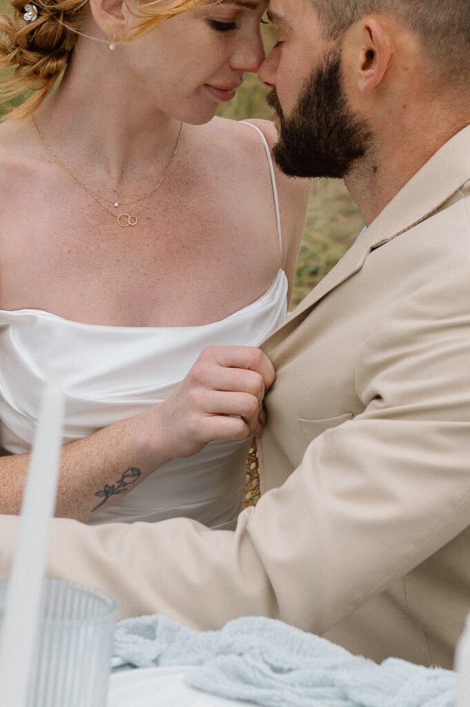 A couple leans into one another for a kiss after their wedding ceremony. 
