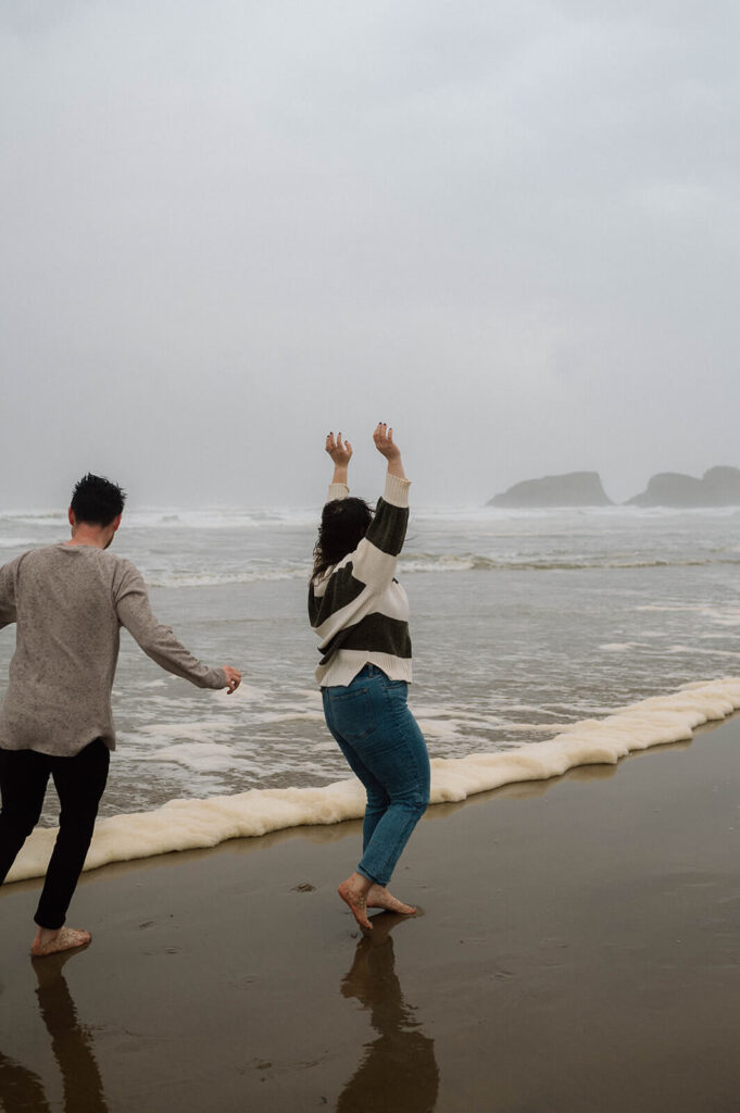 A couple celebrates their beach engagement in the rain. 