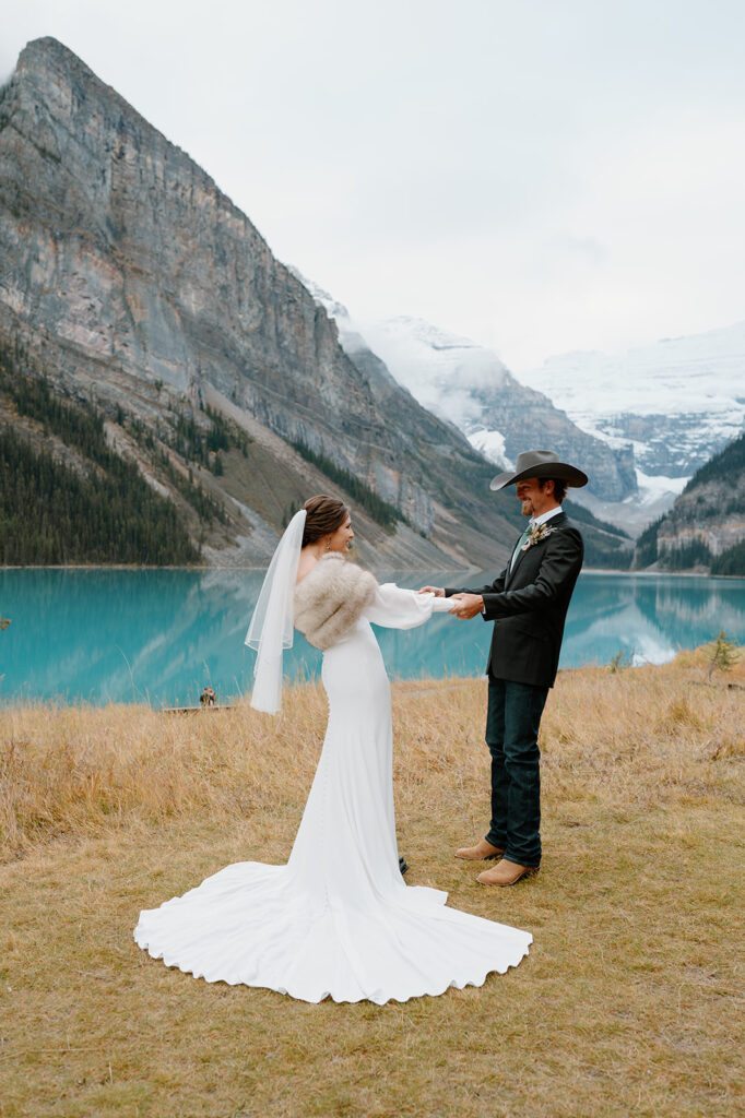 A couple stands near the shores of Lake Louise during their Banff Canada wedding. 
