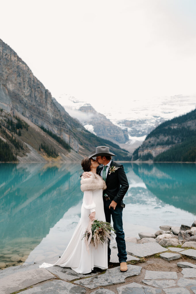 A newly married couple shares a kiss near Lake Louise after saying their vows during their Banff elopement. 