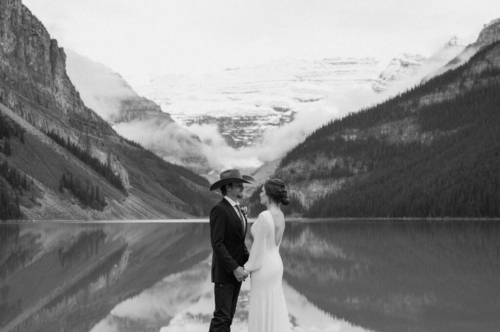 An adventure elopement couple stands near Lake Louise during their Banff Alberta wedding. 