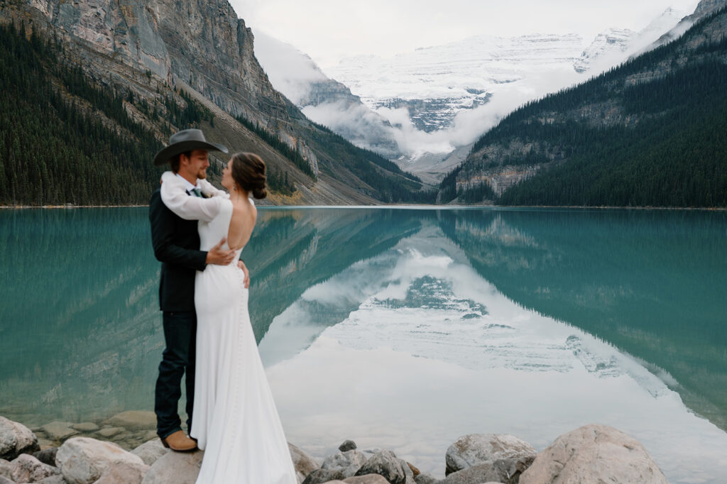 A couple embraces near Lake Louise during their Banff elopement in Alberta.