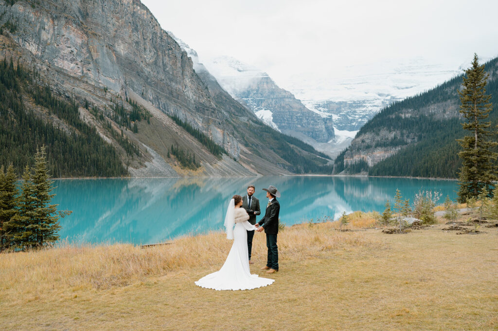 Cole from Married By Cole officiants a wedding along Lake Louise during a couple's Banff elopement in Alberta. 