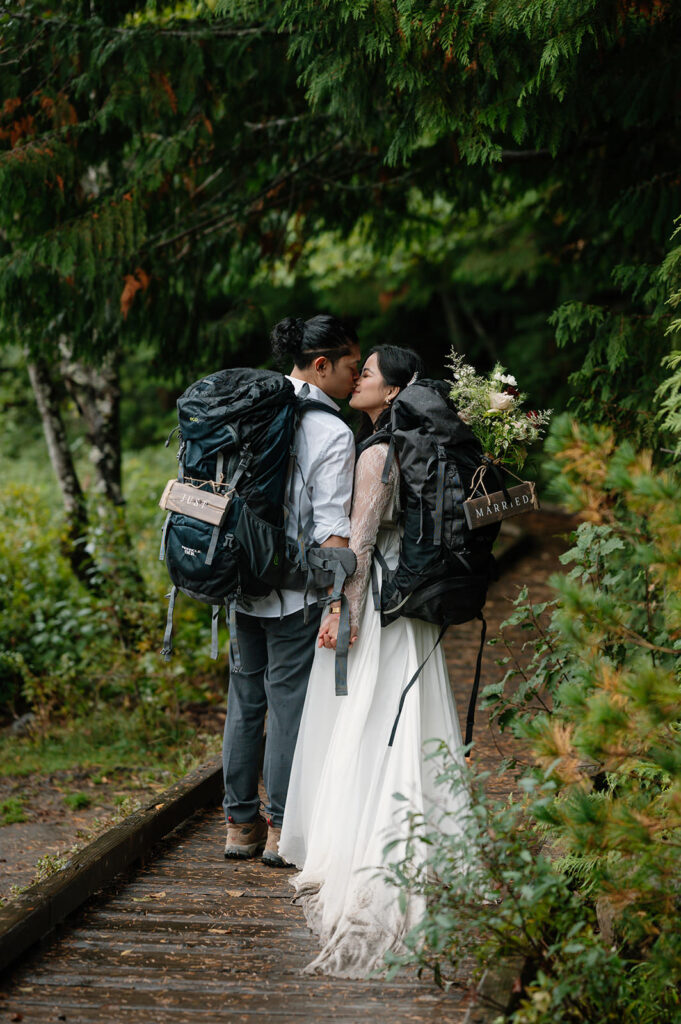 A couple kisses on a wood plank bridge at Trillium Lake.