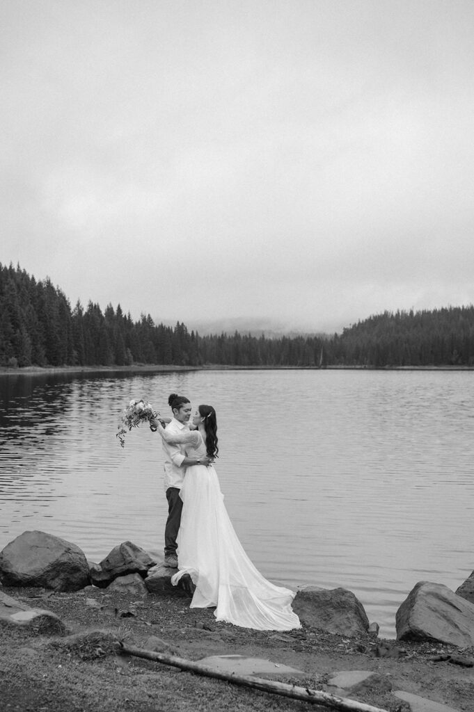 A couple poses along the shores of an Oregon alpine lake.