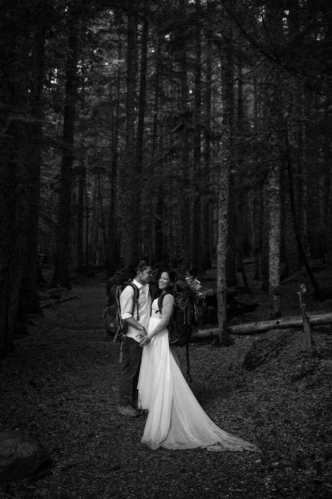 A couple stands in a pine forest near Trillium Lake during their wedding ceremony.