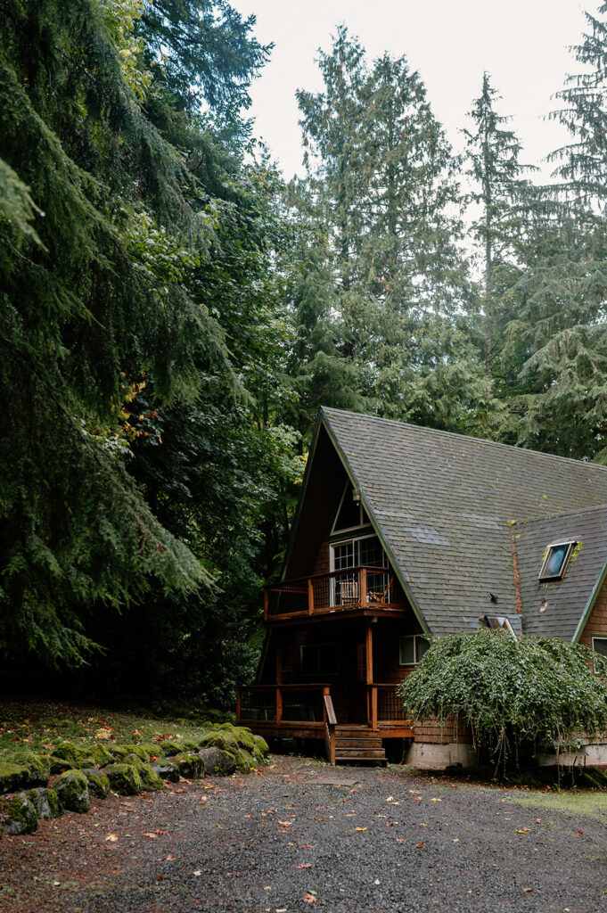 A rustic A-Frame cabin is seen in an Oregon forest.