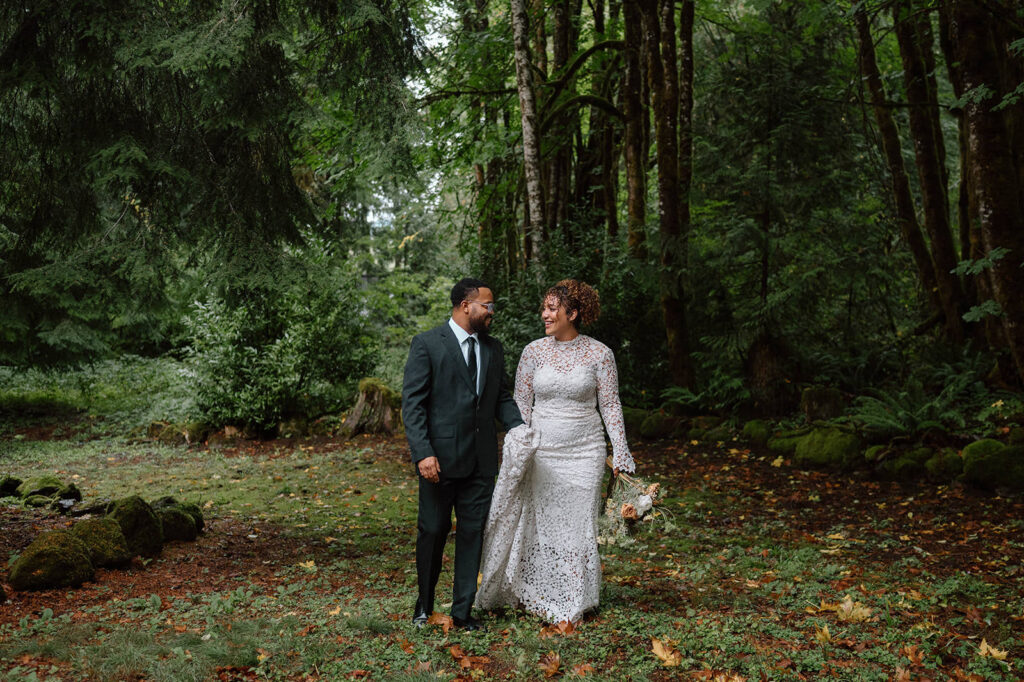 A couple walks in a forest in Oregon during their elopement.