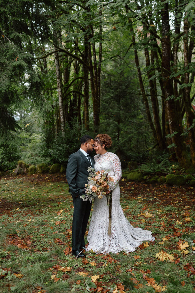 A couple stands amidst evergreens during their Oregon elopement.
