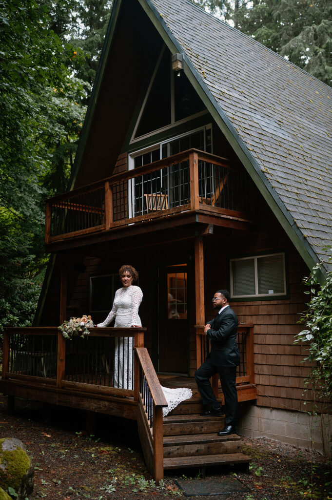 A couple stands on the steps of an Oregon Airbnb near Mt. Hood.