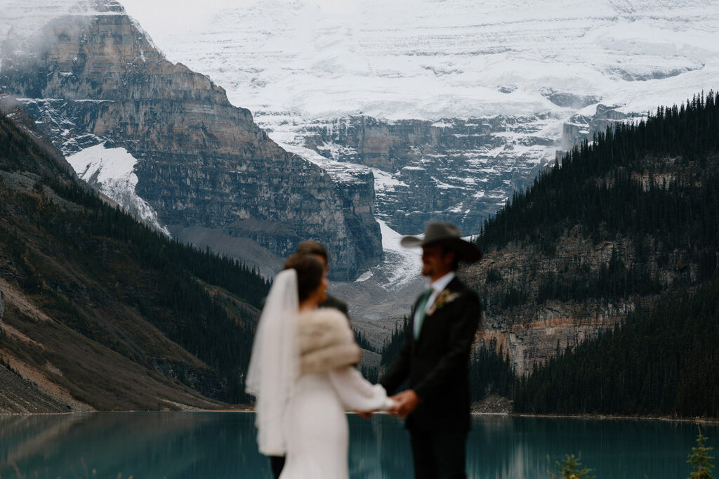 A couple is seen with their officiant Cole with Married by Cole, during their Lake Louise elopement in Banff. 