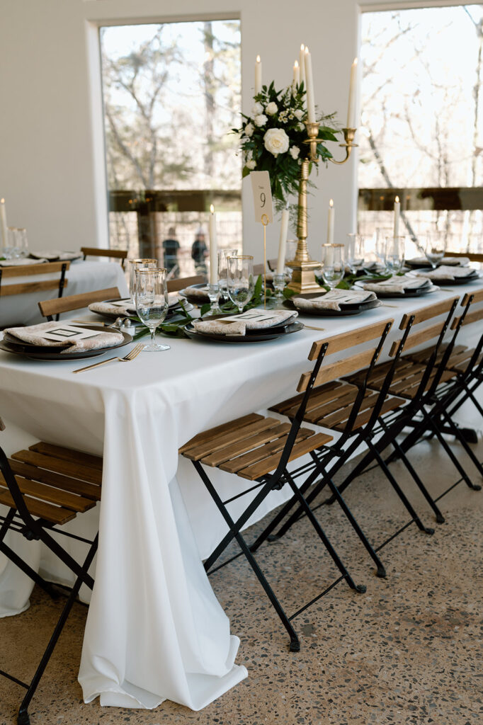 A microwedding reception tablescape features a large, gold candelabra as a centerpiece. 