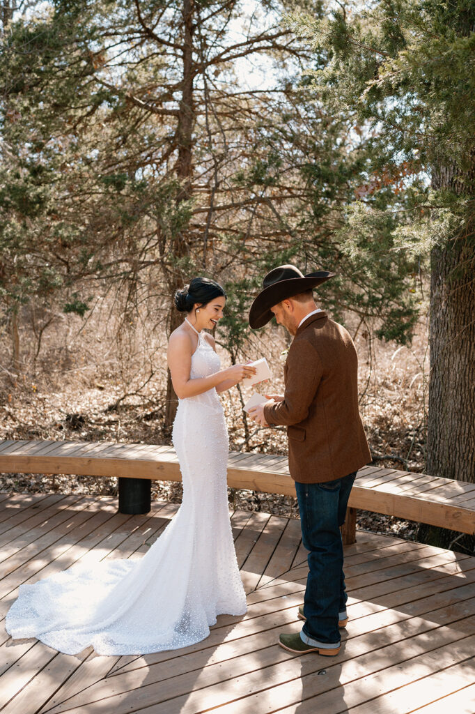 A bride and groom exchange private vows on a wooden patio before celebrating their outdoor mircrowedding. 