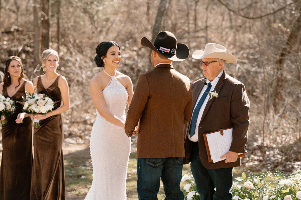 A bride and groom recite wedding vows during their microwedding ceremony outdoors.